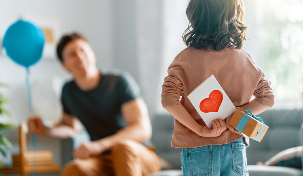 Photo d'un enfant qui donne un cadeau à son père, à l'occasion de la fête des Pères.